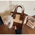 Dettaglio di una borsa a secchiello retrò crema con finiture marroni e charm a coniglio - Con Ciondolo in Peluche / Bianco Sporco