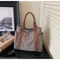 Detail of canvas tote bag with front snap pocket and woven handles for commute - Gray