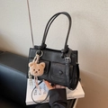 Elegante borsa a mano in pelle nera con tasche anteriori e ciondolo orsetto di peluche - Nero con ciondolo