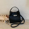 Détail d'un sac seau en cuir grainé noir avec fermoir argenté et breloque ours en peluche - Noir (avec pendentif)