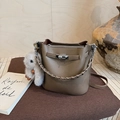 Detail of warm brown lychee leather bucket bag with silver twist lock and woven handle - With Charm / Elephant Gray