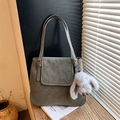 Close-up of dark grey bucket tote bag showing lychee grain texture and plush bunny charm - With Charm / Light Green
