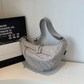 Vue détaillée du sac demi-lune matelassé gris clair avec texture en nylon et double fermeture - Gris