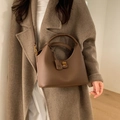 Borsa a secchiello in pelle marrone grana litchi con fibbia dorata e tracolla - Marrone