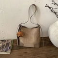 Detail of matte khaki bucket bag on wooden table with a cute brown teddy dog pendant - Khaki With Pendant