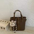 Detailed view of dark brown pebbled leather bucket bag with a cute plush bear charm - Brown with Pendant