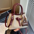 Beige canvas and burgundy leather bucket bag with top handles and adjustable strap - With Charm / Red