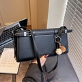 Black leather baguette shoulder bag featuring a fuzzy charm and silver hardware - Black