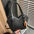 Borsa a secchiello nera con trama plissettata e ciondolo etnico con perline - Nero