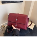 Dettaglio borsa a tracolla in ecopelle bordeaux con cinturino e finiture in metallo - Borgogna