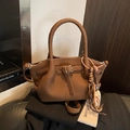 Brown litchi leather bucket bag with thick round handle and woven tassel detail - With Charm / Brown
