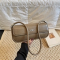 Braune Baguette-Tasche aus genarbtem Leder mit silbernem Logo auf weißem Steppdekor - Eichenkamel