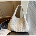 Detail of quilted cloud pattern on a large beige puffer tote bag with magnetic closure - Off-white