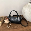 Detail of black cylinder bag with shiny wrinkled texture and cute bear charm accent - With Charm / Black