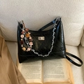 Black quilted bucket bag with chain strap and colorful beaded charm on book - With Charm / Black