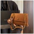 Close-up of vintage brown shoulder bag with gold chain strap, twist lock, and plush charm - With Charm / Brown