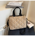 Detail of beige quilted tote bag featuring delicate white bow embroidery and black handles - Khaki
