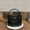 Schwarze Beuteltasche aus Leder mit Litschimuster, Tragegriff und Metalldrehverschluss - Schwarz