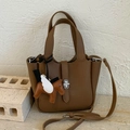 Dark brown pebble leather bucket bag with silver clasp and winged horse charm - With Charm / Brown