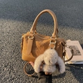 Sac Boston tressé marron avec bandoulière et porte-clés lapin gris sur le trottoir - Avec Pendentif / Marron