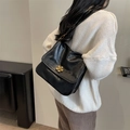 Vintage black pleated leather crossbody bag with floral gold buckle worn by a model - Black