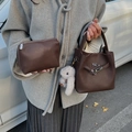 Dark brown lychee pattern leather bucket bag set with a plush bunny charm on a model - Coffee with Pendant