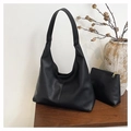 Detail van zwarte tote bag met litchi patroon en bijpassende pouch op houtvlak - Zwart