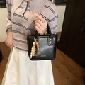 Retro black leather bucket bag with vintage wooden beaded charm and gold logo detail - Black