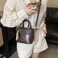 Brown vintage PU leather bucket bag with beaded charm shown on model in casual setting - Brown