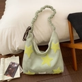 Détail du sac croissant vert aux étoiles jaunes et bandoulière froncée sur lit - Vert matcha