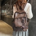 Retro donkerbruine leren rugzak met teckel- en chocoladehanger in een lifestyle-setting - koffiekleur