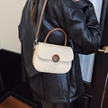 Detalle de bolso bandolera de lona beige con correa de cuero marrón y hebilla decorativa - Blanco Roto