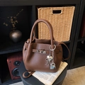Sac seau en cuir marron grainé avec fermoir argenté et breloques cœur sur tabouret - Marron avec pendentif