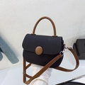 Detalle del bolso bicolor con hebilla grande marrón y acabado de textura elegante - Negro