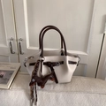 Detail of cream pebbled leather bucket bag with brown handles and a dachshund dog charm - White with Pendant