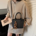 Black vegan leather bucket bag with white contrast stitching and beaded tassel on model - Black with Pendant