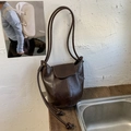 Bolso tipo cubo marrón oscuro con textura plisada vintage y correas finas con nudos - Marrón