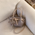 Taupe pebbled leather bucket bag with dog charm and detachable strap on beige sofa - Beige Gray With Pendant
