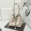Detail of beige woven bucket bag featuring silver drawstring and pearl pendants - White