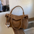 Dark brown retro leather tote bag with a white dog plush charm and metal buckle - Brown with Pendant