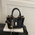 Bolso tipo cubo de cuero negro con patrón de lichi y cierre de reloj con dijes - Negro
