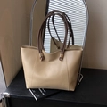 Minimalistische beige Leder-Einkaufstasche mit dunkelbraunen Griffen und Goldringen - Khaki