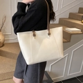 Minimalistische cremeweiße Leder-Tragetasche mit dunkelbraunen Trägern und Goldringen - Gebrochenes Weiß