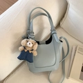 Light blue lychee texture bucket bag with cute brown bear charm on sofa - Blue with Charm
