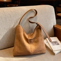 Vintage braune Tragetasche aus Wildleder mit verstellbarem Gurt auf dem Sofa - Braun