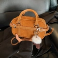 Retro bowlingtas van suède in camel met gespen en een wit pompon accessoire - Met Hanger / Bruin