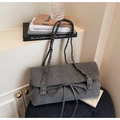 Dettaglio borsa a spalla in camoscio grigio con tracolla intrecciata, borchie e fiocco - Grigio