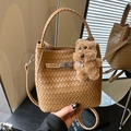 Light brown woven bucket bag featuring a plush dog charm and silver metal twist-lock buckle - Khaki (With Puppy Charm)