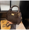 Detail of vintage dark brown small square bag with golden hardware and round handles - Brown