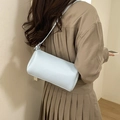Light blue lychee textured leather baguette bag shown as a crossbody on model - Blue